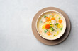 Creamy fish chowder soup in bowl on concrete background