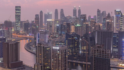  Skyline with modern architecture of Dubai business bay towers day to night . Aerial view