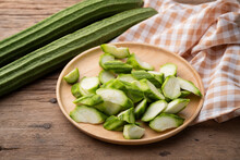 Sliced Fresh Angled Luffa (Ribbed Gourd) Fruits On Wooden Bowl