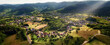 Aerial panorama of a scenic landscape with an idyllic European town surrounded with hills, forests and fields