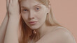 © supamotion - Beautiful young woman with absolutely no makeup gently smiles against neutral brown pastel background. Studio shot, soft lighting