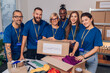 © Zamrznuti tonovi - Diverse volunteers working in a charity donation center and packing clothes and food