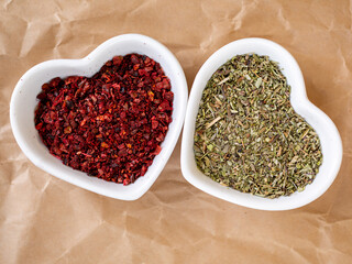 Mixture of Italian herbs and dried paprika in heart shaped white bowls