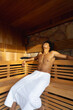 © Wavebreak Media - Vertical of biracial man wearing towel relaxing with eyes closed in sauna, copy space