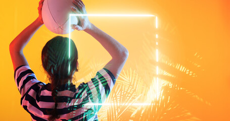 Wall Mural - Illuminated rectangle and plants over rear view of caucasian female rugby player throwing ball