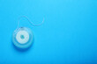 © New Africa - Container with dental floss on light blue background, top view. Space for text