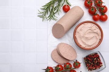 Delicious liver sausage, paste and other products on white tiled table, flat lay. Space for text