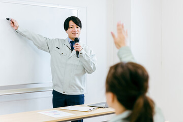 Poster - 工場・会議室で講習・セミナー・勉強会・プレゼンをする作業服を着たエンジニア・講師・技術者の男性
