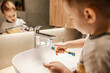 © Dusan Petkovic - Selective focus on boy's hand washing toothbrush under the tap in bathroom.