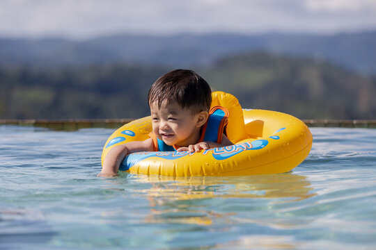 Portrait image of​ 1-2 years old​ childhood​ child happy and enjoying playing water on pool