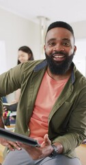 Wall Mural - vertical video of african american man smiling and using tablet in slow motion