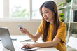 © KMPZZZ - Internet banking, Online shopping at home, asian young woman hand in typing on keyboard, holding credit card, using laptop computer, spending money with purchase on store at home. Shopaholic ecommerce