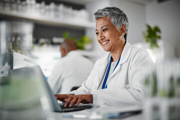 Wall Mural - Scientist, senior woman and lab with laptop, research and plants with analytics, pharmaceutical study and focus. Elderly science expert, computer and typing for data analysis for goal in laboratory