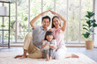 © aekkorn - Real estate and mortgage concept : Family with child having fun in new home. Joyful first-time buyers in living room. Real estate, residential mortgage, moving into dream house.