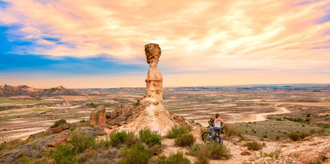 Wall Mural - Monegros desert sandstone and woman on mountain bike- Spain