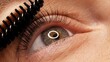 © Valua Vitaly - Making makeup in a beauty salon. Applying black mascara to the eyelashes with a makeup brush. Close-up of a woman's eye. Lengthening of the eyelashes after lamination..