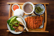 Taiwanese braised pork rice with salted crispy pork set dinner on wooden tray and isolated wooden background