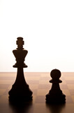 Fototapeta Tęcza - chess King and Pawn on the chessboard, in silhouette