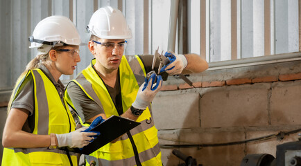 Engineer manager and female technician use equipment tools in metalwork. Vernier calipers are widely used in scientific laboratories and in manufacturing for quality control precision measurements.