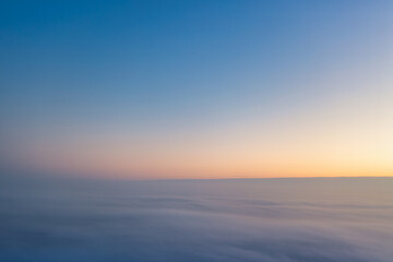 Wall Mural - Yellow and blue dawn over clouds, concept, travel and leisure.