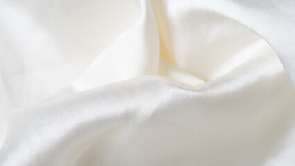 White silk fabric - soft, and delicate with shine, folds, creases. Smooth elegant silk  background