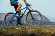 © Real Sports Photos - closeup man on mountain bike riding trail in background of mountain