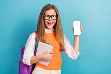 Sticker - Photo of cute positive girl demonstrate empty space telephone display isolated on blue color background