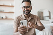 © kite_rin - Young man using smartphone at home. Handsome smiling men looking at mobile phone in his room. Communication, home work or study, connection, mobile apps, technology, lifestyle concept