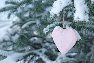 Wall Mural - valentines day background with wood heart on snow covered pine branch