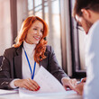 © kerkezz - Business people man and woman sitting at the table in the office and signing the contract.