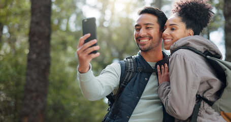 Canvas Print - Hiking, selfie and young couple in forest smiling, happy and enjoy nature together. Fitness, wellness and Asian man with black woman taking picture with phone on adventure, trekking and walk in woods