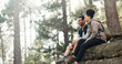 © Nicholas F/peopleimages.com - Hiking, forest and nature couple people on rock for journey, adventure or wellness lifestyle with trees, fitness gear and backpack. Trekking, relax and diversity friends travel in mountains or woods