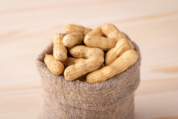 Wall Mural - Small bag full of unpeeled peanuts. Tasty fresh nuts close up