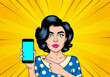 Attractive sexy girl in specs with a phone on her hand in a comic style. Pop art woman holding and showing a smartphone.
