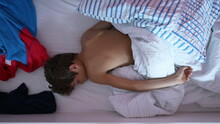 Young Boy Lying In Morning Bed Asleep. One Male Kid Top View Laid Under Blankets Sleeping. Wake Up Call