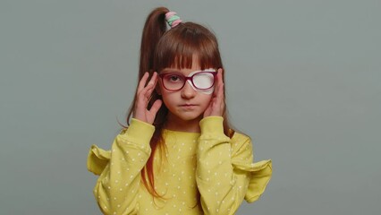 sick ill preteen girl looking at camera having protective bandage plaster patch scratch on one eye. 