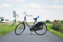 Vintage Black Typically Dutch Bicycle With Worn Leather Seat Is Propping Up On Bike Path, Groningen, Netherlands