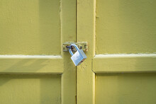 Rustic Yellow Wood Door Closed With Padlock. Security Concept, Copy Space.