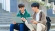 © NanSan - Attractive asian college student using laptop and tablet studying with group of friends together with english language classroom, social media and education concept.