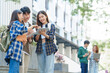 © NanSan - Attractive asian college student using laptop and tablet studying with group of friends together with english language classroom, social media and education concept.