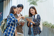 © NanSan - Attractive asian college student using laptop and tablet studying with group of friends together with english language classroom, social media and education concept.