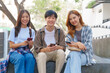 © NanSan - Attractive asian college student using laptop and tablet studying with group of friends together with english language classroom, social media and education concept.