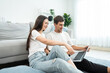 © Kawee - Caucasian young couple using laptop computer in living room at home.