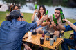 © Kawee - Group of diverse friend having outdoors camping party together in tent.