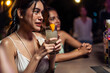 © Kawee - Beautiful young woman having fun, drinking alcohol cocktail in a bar.