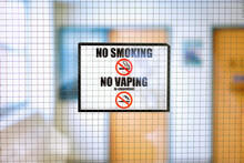 No Smoking Sign And No Vaping Sign With Blurred Indoor Office Building Campus Background. 