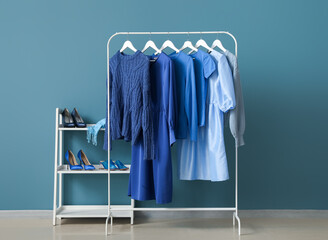Wall Mural - Rack with blue clothes and shoe stand near color wall