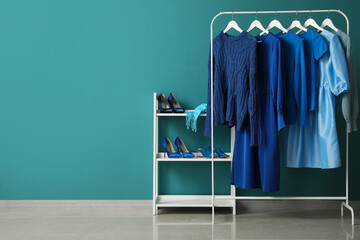 Wall Mural - Rack with blue clothes and shoe stand near color wall
