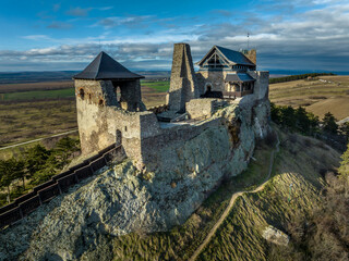 Wall Mural - Aerial view of partially restored Boldogko, medieval Gothic castle in Borsod county Hungary with round gate tower, donjon cloudy blue sky background