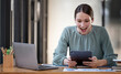© NAMPIX - Portrait of excited businesswoman looking at digital tablet with satisfaction, sitting at her desk office.